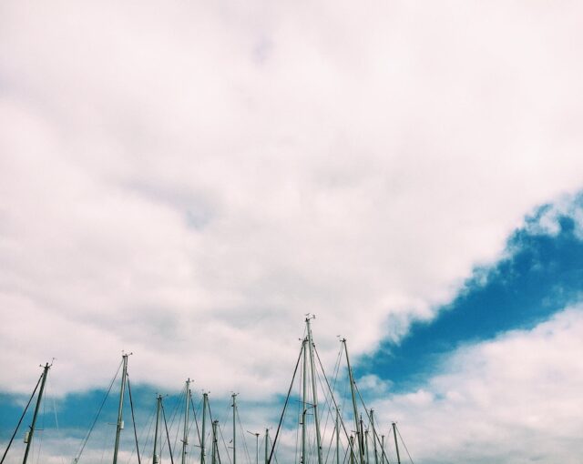 sailboats with deflated sails under cloudy sky
